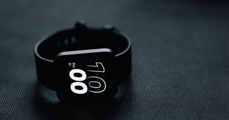 Black fitness watch resting on dark fabric