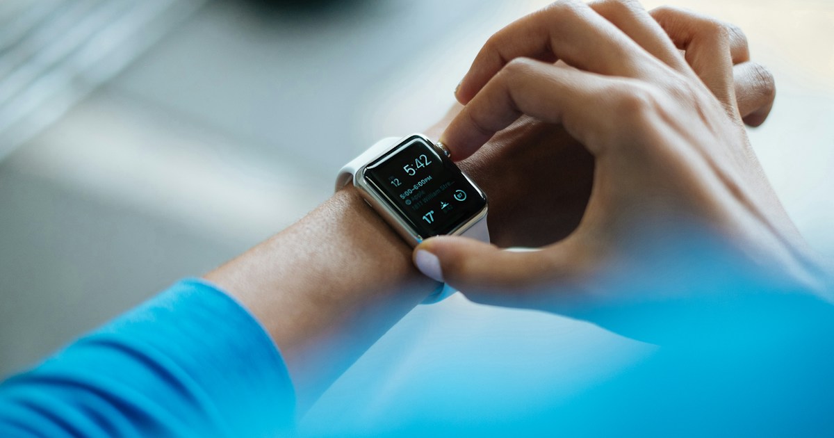 Person operating a smartwatch with a white wristband
